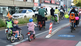 Erwachsene und kleine Kinder fahren mit dem Rad auf der Straße
